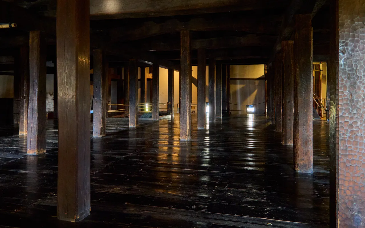 Timber pillars and polished wooden floor inside Matsumoto Castle keep